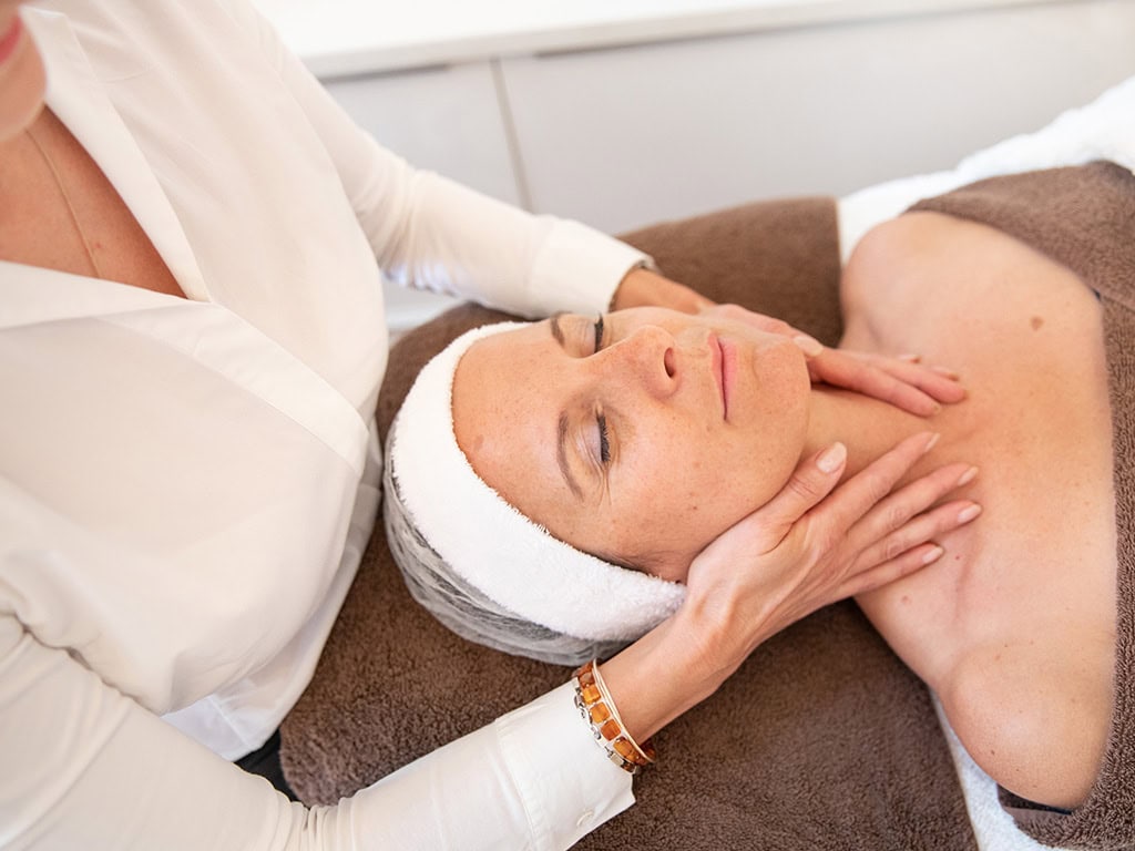 Frau bei entspannender Gesichtsmassage im Spa