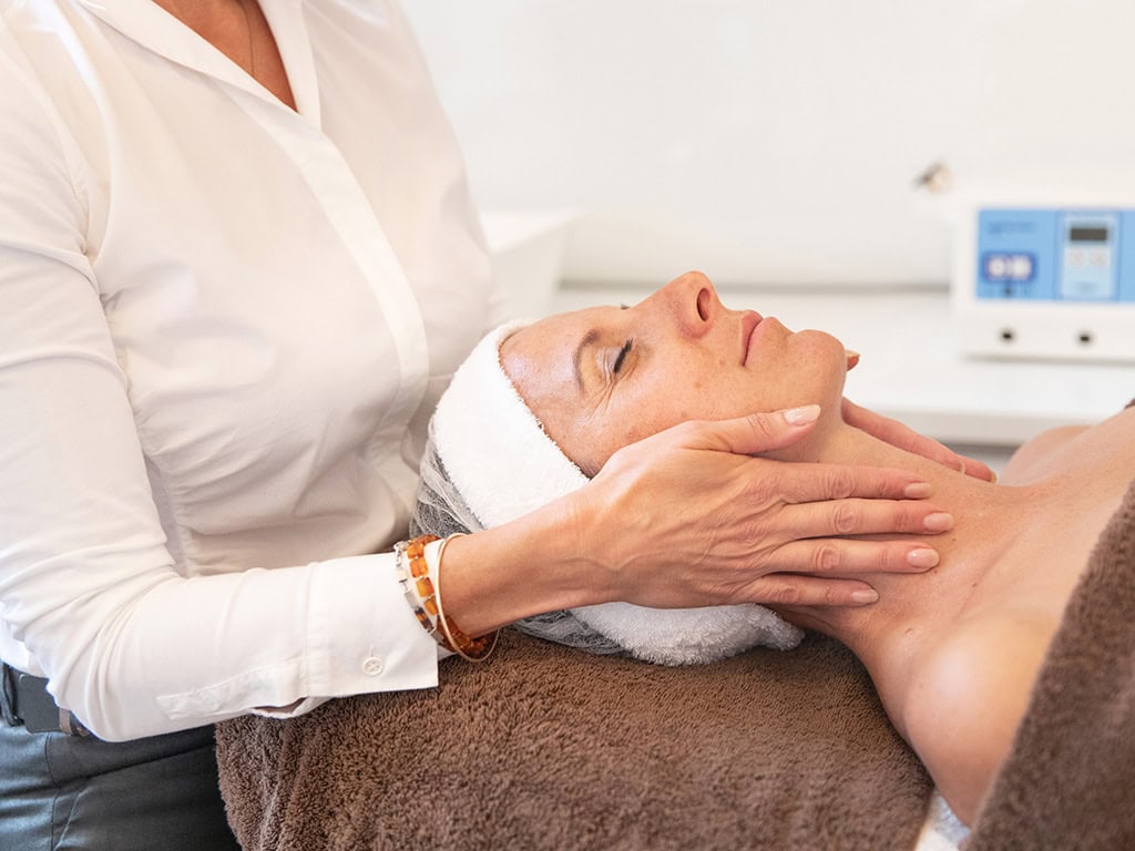 Frau erhält Gesichtsmassage in Kosmetikstudio